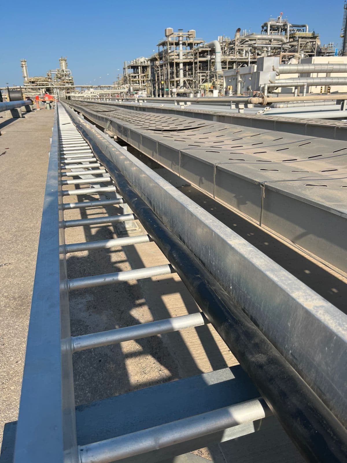 Heavy industrial site with engineers in PPE near piping and control panels